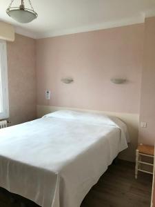 una camera da letto con un grande letto bianco in una stanza di Le Bretagne ad Assérac