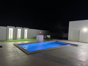 a swimming pool in a courtyard at night at Dar khadouja in Taguermess