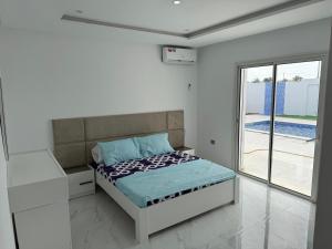 a bedroom with a bed and a large window at Dar khadouja in Taguermess +19 photos