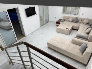 a living room with a couch and a tv at Dar khadouja in Taguermess