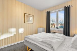 a bedroom with a large bed and a window at Halden Grand hotell in Halden