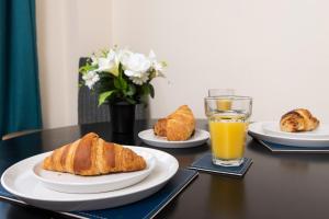a table with plates of food and a glass of orange juice at 8 Guests - 4 Bedrooms - Parking - Garden in Norwich
