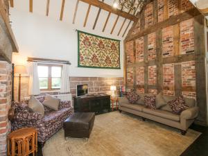 un salon avec deux canapés et une fenêtre dans l'établissement Courtyard Cottage, à Great Bolas