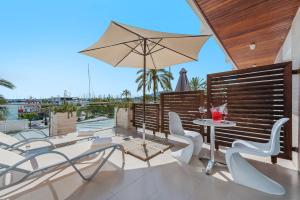 patio con tavolo, sedie e ombrellone di Hostal Brisa Marina a Port d'Alcudia
