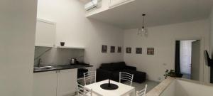 a kitchen and a living room with a couch and a table at Little Button House Marina in Cagliari