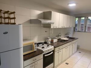a kitchen with a white refrigerator and a stove top oven at Microcentro Mendoza in Mendoza