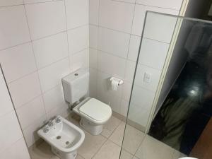 a white bathroom with a toilet and a sink at Microcentro Mendoza in Mendoza