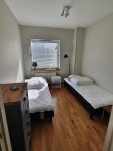 Ruda3 sovrum 4 bäddar 4 sovplatser的一间卧室设有两张床、一个窗口和一张书桌