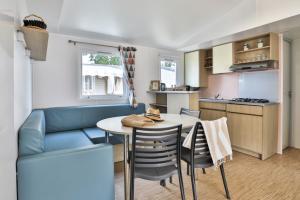a living room and kitchen with a table and chairs at Camping maeva Club L'Atlantique in Angles