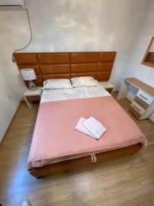 a bedroom with a large bed with a pink blanket at Centerside Apartment in Ulcinj