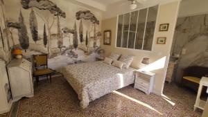 a bedroom with a bed and a wall mural at Le N 9 in Argeliers