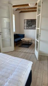 a room with a bed and a couch and a table at Entire multi-room apartment in patrician villa in Slagelse