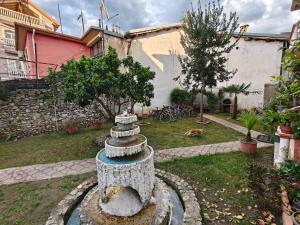 a garden with a stone fountain in a yard at Bliss Inn Hostel & Tours in Shkodër