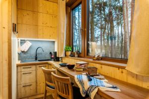 a kitchen with a table and chairs and a window at KarpatyGlamp in Rudimov
