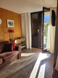 a living room with a couch and a sliding glass door at Appartement Reallon 5 personnes en rez de jardin in Réallon +27 photos