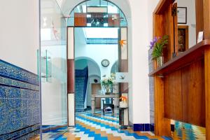 a hallway with a blue and white tile floor at Hostal Casa Alborada in Conil de la Frontera
