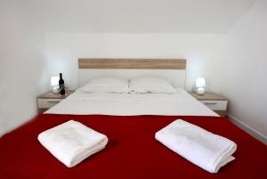 a bed with two white pillows on a red blanket at SPA Villa ALEMI, Private Pool, Sauna & Free Parking in Brodarica