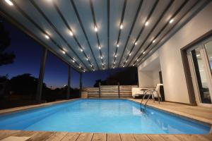 a swimming pool with lights on a house at SPA Villa ALEMI, Private Pool, Sauna & Free Parking in Brodarica +37 photos