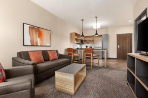 a living room with a couch and a table at Candlewood Suites Huntsville - Research Park by IHG in Huntsville