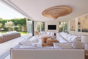 un soggiorno con divani bianchi e una TV di Villa Les Peupliers avec piscine privée et sauna a Royan