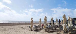 un gruppo di sedie e ombrelloni su una spiaggia di 3 chambres à 200m mer et commerces a La Bernerie-en-Retz