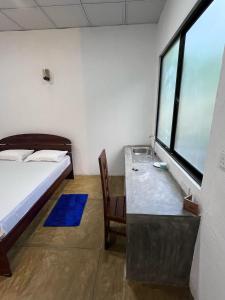 a bedroom with a bed and a desk and a window at White House by Araliya in Unawatuna
