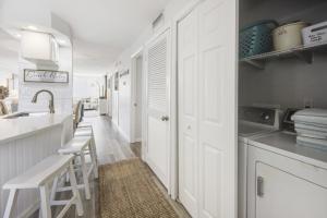 a kitchen with white cabinets and a sink at Loggerhead 282 condo in Sanibel