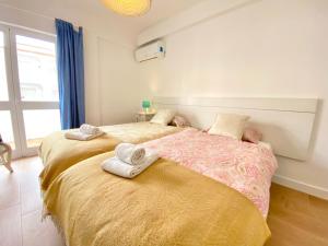 Un dormitorio con dos camas con toallas encima. en Apartamento 2M - Praia do Carvoeiro, en Carvoeiro 26 fotos más