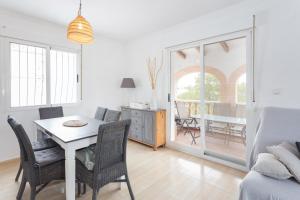 Un comedor blanco con una mesa y sillas. en Maison Oliva, en La Font D´En Carròs