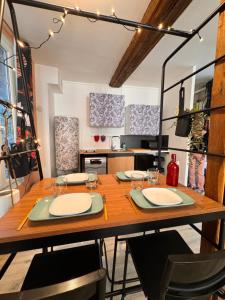 a dining room with a wooden table and a kitchen at Logis 2 Caen in Caen +12 photos