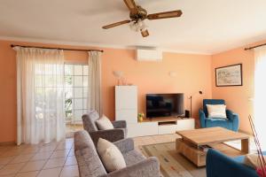 ein Wohnzimmer mit Sofa und Fernseher in der Unterkunft Casa Bonita in Lagoa