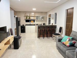 a living room with a couch and a kitchen at Casa temporada in Camaçari