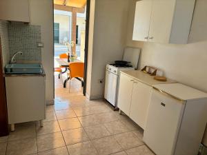 a kitchen with white cabinets and a table with a tableablish at Agriturismo Antico Vigneto in Otranto +78 photos
