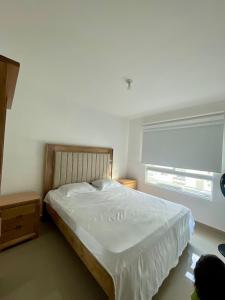 a bedroom with a large white bed with a window at APARTAMENTO al NORTE DE VALLEDUPAR in Valledupar +3 photos