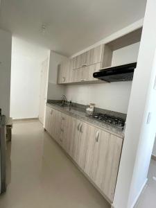 a kitchen with wooden cabinets and a stove at APARTAMENTO al NORTE DE VALLEDUPAR in Valledupar