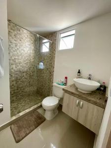 a bathroom with a toilet and a sink and a shower at APARTAMENTO al NORTE DE VALLEDUPAR in Valledupar