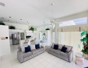 Stunning Sunsets and Water Views في جزيرة ماركو: غرفة معيشة مع أريكتين ومطبخ