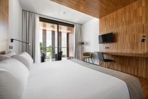 a hotel room with a large bed and a tv at Pousada Ribadumia in Ribadumia