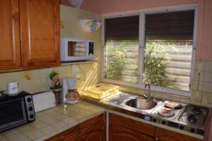 a small kitchen with a sink and a window at Sun Caraibes in Orient Bay