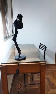 a black lamp sitting on top of a desk at Habitación silenciosa Nº1 en Dpto Compartido in Cordoba