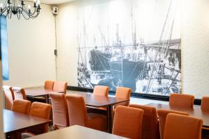 a room with tables and chairs and a picture of a boat at Hiisi Hotel Turku Seaport in Turku