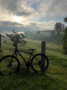 a bike parked next to a pole in a field at Espaço Benviver in Guaratinguetá