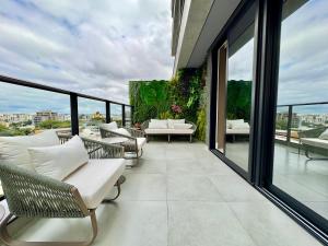 a balcony with chairs and tables on a building at Diamond Batel - Apartamentos by UROOMS in Curitiba +27 photos