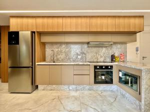 a kitchen with stainless steel appliances and wooden cabinets at Diamond Batel - Apartamentos by UROOMS in Curitiba
