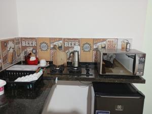 a kitchen counter with a coffee maker and a microwave at Joia do Pepira in Brotas
