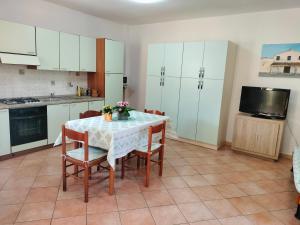 a kitchen with a table with chairs and a television at Casa Giuliana in Pula