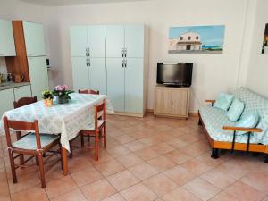 a living room with a table and chairs and a tv at Casa Giuliana in Pula