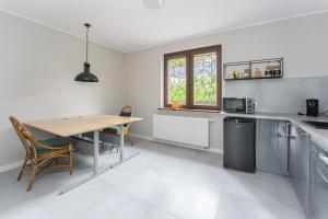 a kitchen with a table and a table and chairs at Apartament Pomarańczowy Gdańsk 80 metrów z widokiem na ogród in Gdańsk +5 photos
