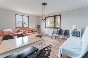 a living room with a table and chairs at Apartament Pomarańczowy Gdańsk 80 metrów z widokiem na ogród in Gdańsk