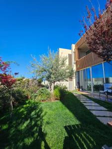a house with a green yard with a lawn at Villa Olive Green Coast in Palasë